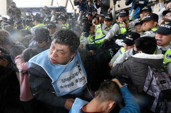 장애인의 날 장애인들의 시위에 최루액을 뿌리는 경찰 (출처)